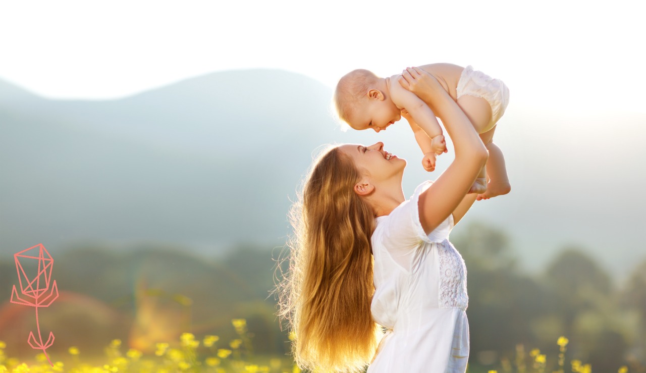 Happy mom lifting baby up in the air